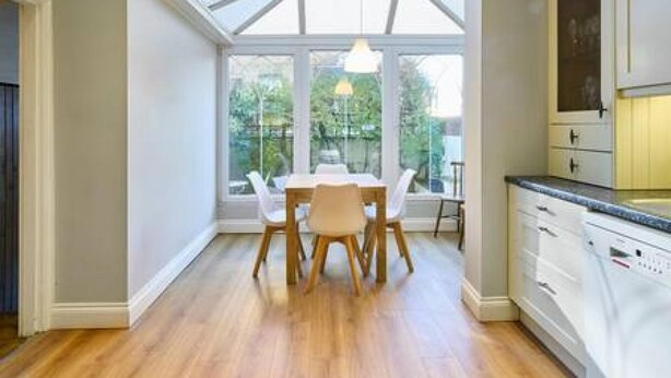 A modern kitchen with a dining area, large windows, and wooden flooring. - Host Stay Bellevue Road (Ramsgate)