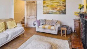 A cozy living room with a sofa, a patterned rug, and a fireplace. - Host Stay Bellevue Road (Ramsgate)