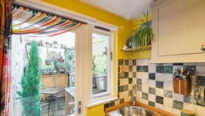 Una cocina con salpicadero a cuadros, un lavamanos y una ventana con vistas al exterior.