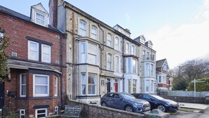A row of terraced houses with a blue car parked in front. - Host Stay Endeavour Sails (Whitby)