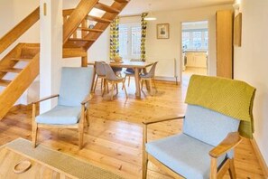 A wooden staircase leading to a dining area with a table and chairs. - Host Stay New Street (Canterbury)