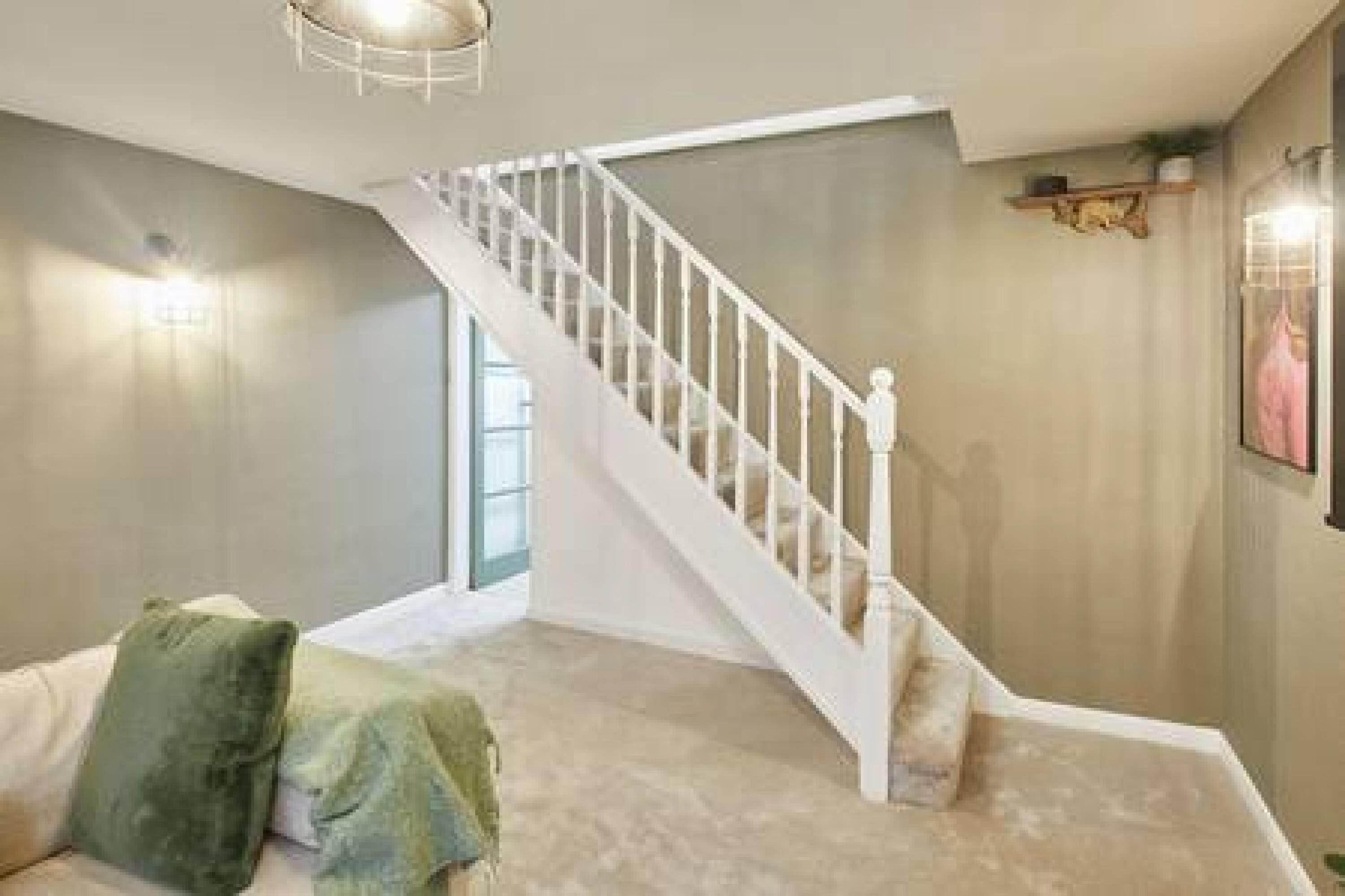 Eine Treppe mit weißen Geländern, die zu einer oberen Etage führt.