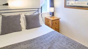 A bedroom with a bed, pillows, a bedside table, a lamp, and a framed picture on the wall. - Host Stay Prospect Place (Canterbury)