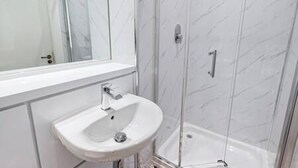 A bathroom with a white sink, a mirror, and a glass shower enclosure. - Host Stay Ropewalks Quarters V (Liverpool)