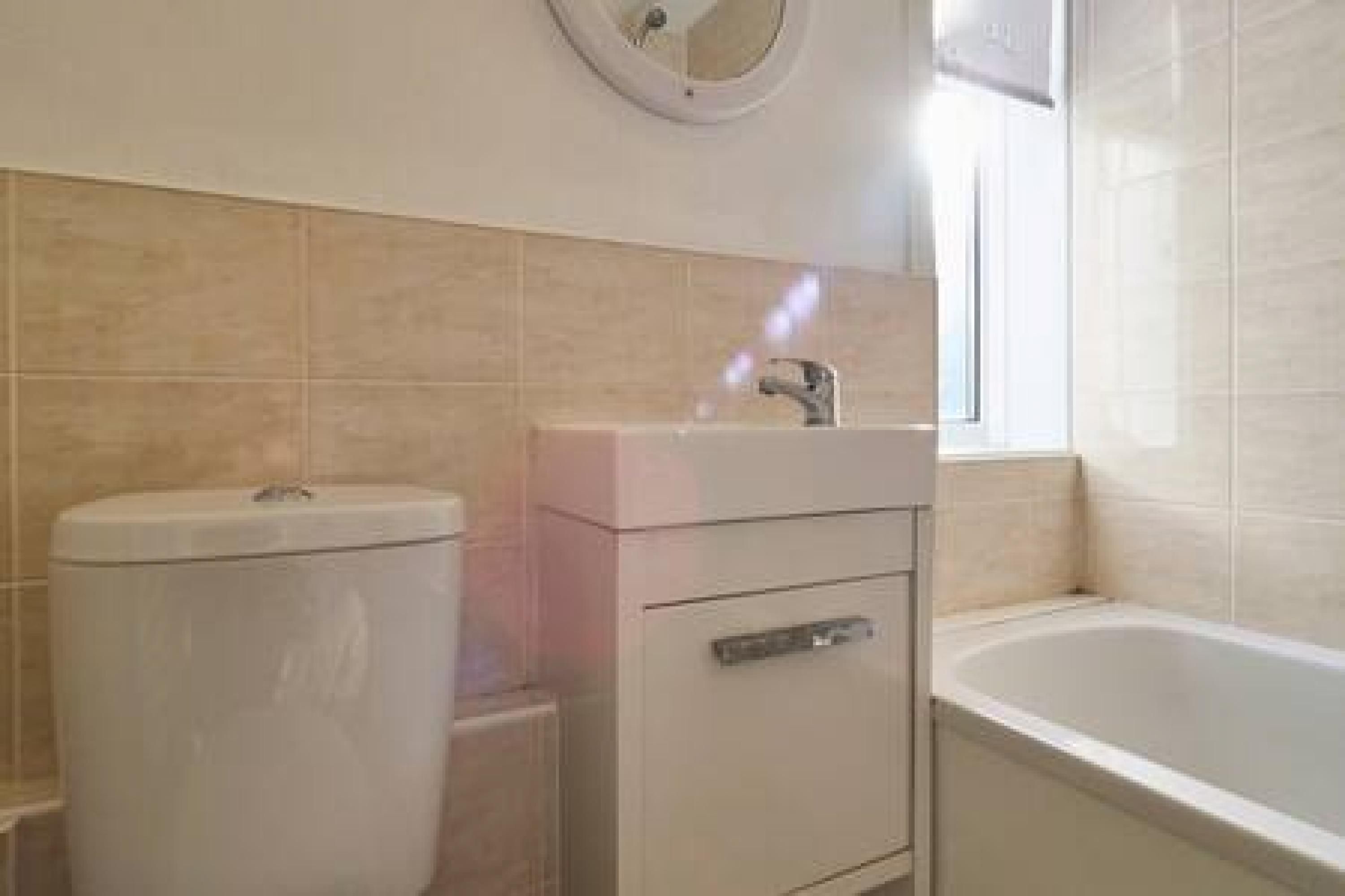 A bathroom with a toilet, sink, and bathtub.