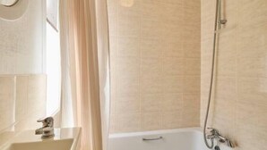 Une salle de bain avec une baignoire, un lavabo et une douche.