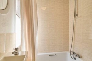 Un bagno con una vasca, un lavandino e una doccia.
