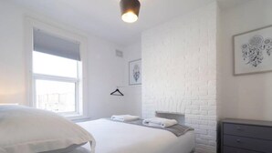 A modern bedroom with a large bed, a dresser, and a window. - Host Stay Herbert Road (Ramsgate)