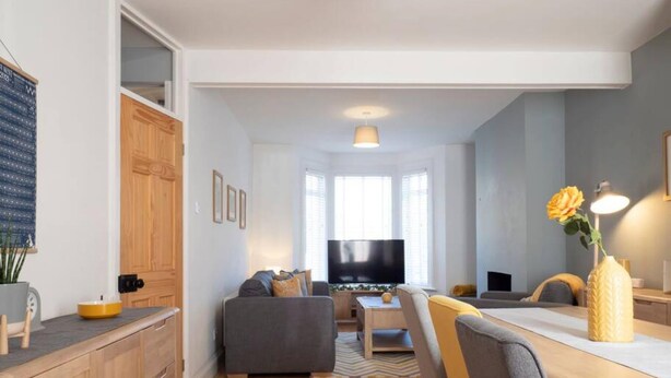 A modern living room with a sofa, TV, and dining area. - Host Stay Herbert Road (Ramsgate)