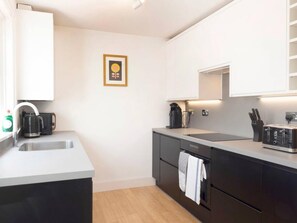 A modern kitchen with a sink, coffee maker, and a microwave. - Host Stay Herbert Road (Ramsgate)