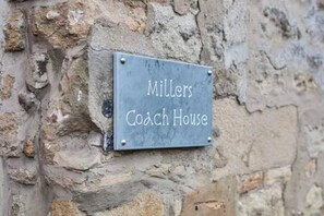 A stone wall with a sign that reads 'Miller's Coach House.' - Host Stay Millers Coach House (Hexham)