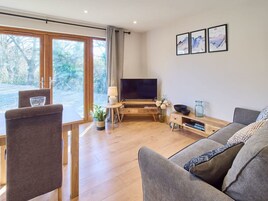 Una sala de estar moderna con televisor, sofá y comedor.