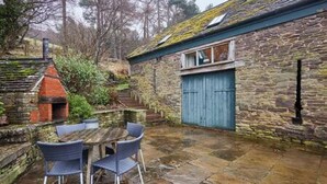 A stone building with a blue door, a small window, and a chimney. - Host Stay Llewenau Draw Barn (Crickhowell)
