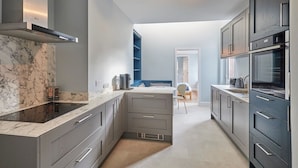 A modern kitchen with grey cabinetry, a marble countertop, and built-in appliances. - Host Stay Mollymac Ground Floor (Saltburn-by-the-Sea)