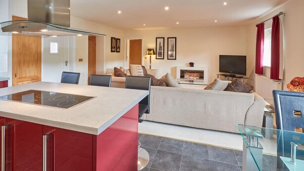 A modern living room with a sofa, a TV, and a glass coffee table.