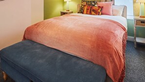 A bedroom with a large bed, two bedside tables, a nightstand, a mirror, and a window with curtains. - Host Stay Hideaway (Morpeth)