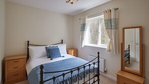 A bedroom with a bed, bedside tables, a window with curtains, and a mirror. - Host Stay 57 Woodland View (Holmfirth)