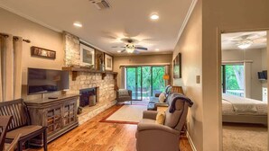 A modern living room with a fireplace, a television, and a sofa. - CW C113 Comal Vista (New Braunfels)