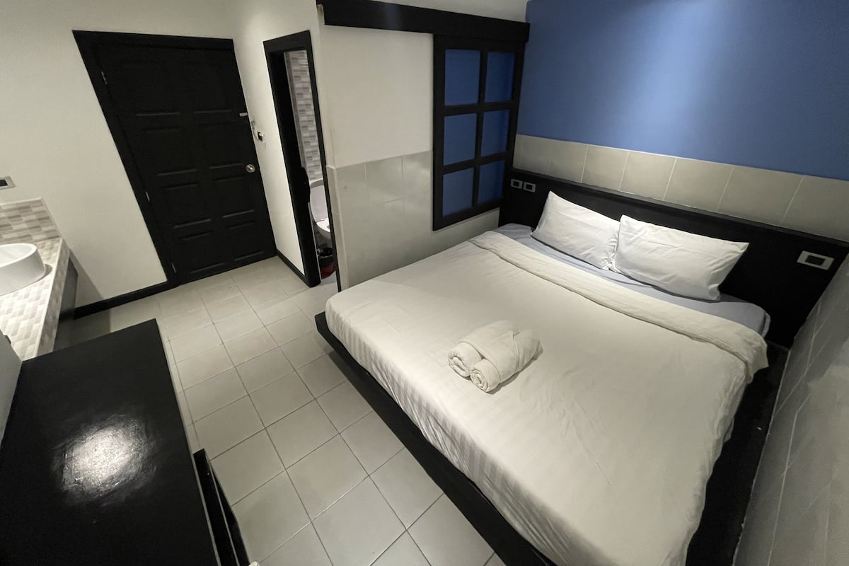 Ein Hotelzimmer mit Bett, Schreibtisch, Badezimmer und Tür.