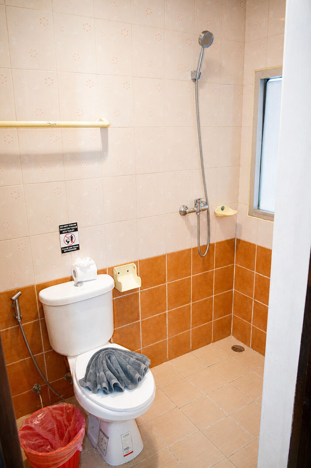 Un baño con inodoro, ducha y secamanos.