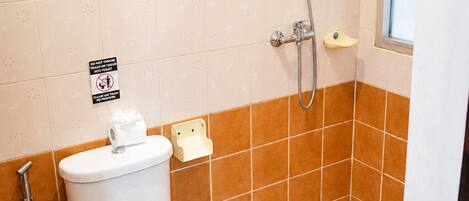 Un baño con inodoro, ducha y secamanos.