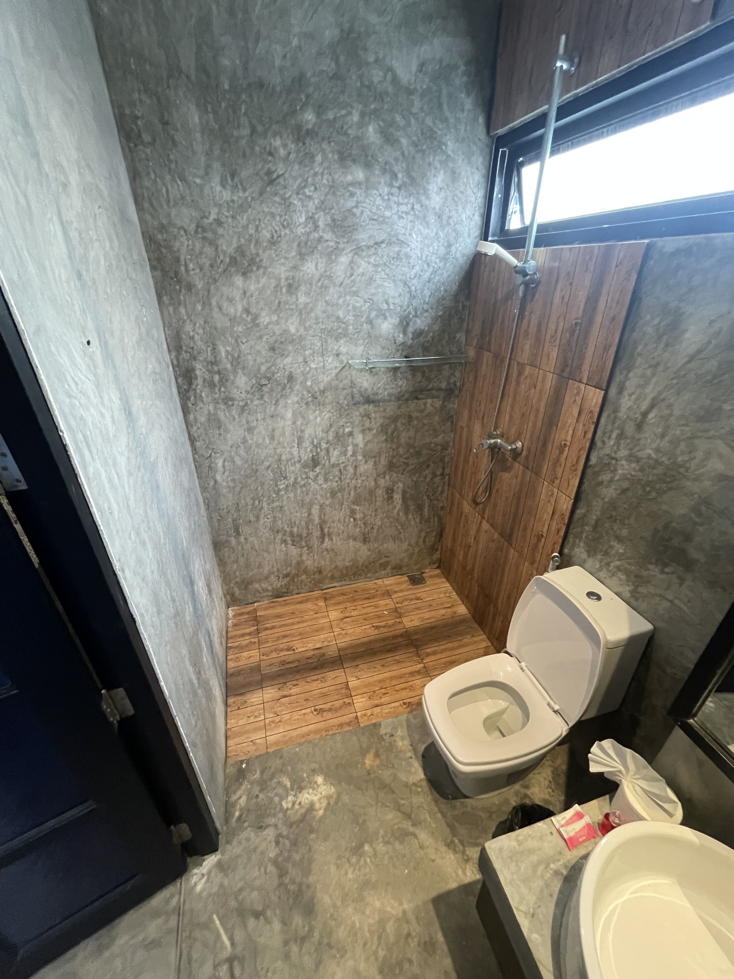 A bathroom with a shower, toilet, and sink.