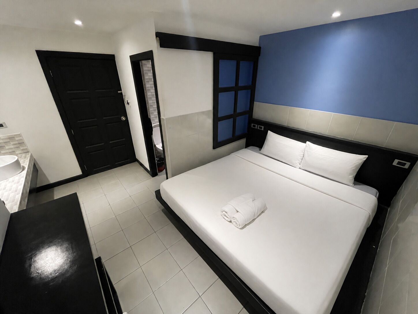 Een hotelkamer met een bed, bureau en badkamer.