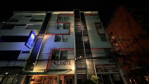 A multi-story hotel with a prominent 'ISLANDA' sign, featuring a modern facade with red accents and a balcony. - Cocoon Islanda Hotel (Patong)