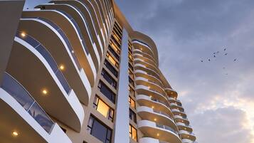 A high-rise building with multiple balconies and a curved facade.