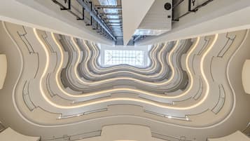 Interior moderno com uma escadaria espiral central e um claraboia.