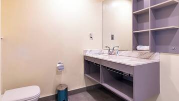 Un baño moderno con inodoro, lavabo y espejo.