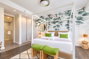 Una habitación de hotel con cama, baño y vistas al exterior.