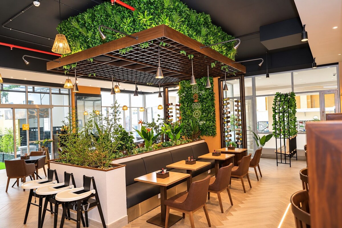 Un restaurante moderno con pared verde, techo de madera y varias zonas de estar.