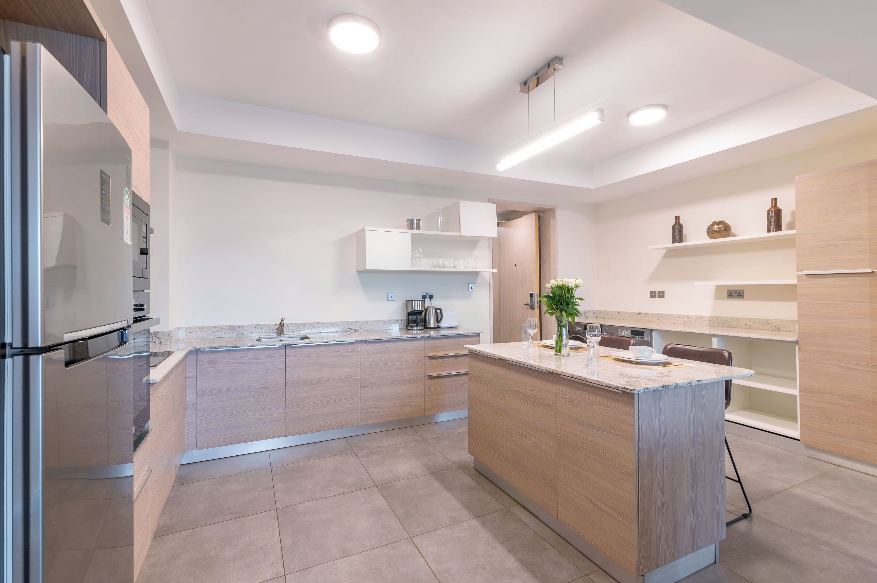 A modern kitchen with a central island, built-in appliances, and a minimalist design.