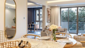 Uma área de refeições com uma mesa posta para dois, um espelho e vista para o exterior.