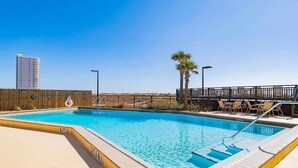 Una piscina rectangular con un muelle de madera y una barandilla metálica.