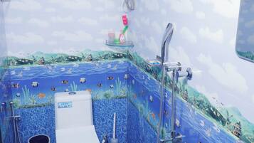 Ein Badezimmer mit Fliesen im blauen Meer-Design, einer Toilette, einem Waschbecken und einer Dusche.