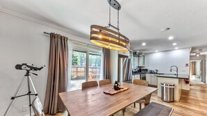 Een moderne keuken met een houten eettafel, een statief en een telescoop.