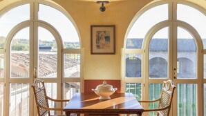 A dining area with a table and chairs, a decorative urn, and a painting on the wall. - Villa Fogliacchi - Five Bedroom Villa, Sleeps 10 (Fogliacchi)