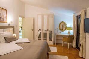 Ein Schlafzimmer mit einem Bett, einem Schreibtisch, einem Stuhl, einem Kleiderschrank und einem Fernseher.