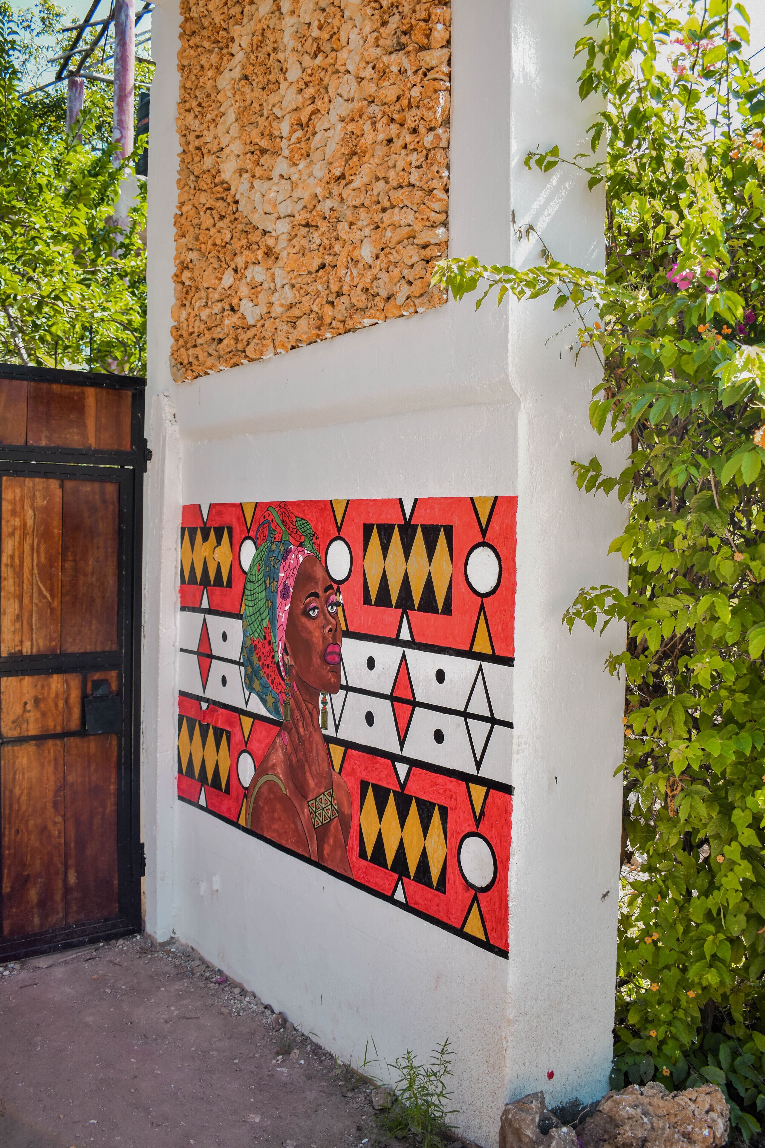 A wall with a colorful mural and a wooden door.