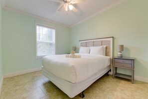 A bedroom with a bed, a nightstand, a ceiling fan, and a window with blinds. - Loggerhead Lagoon - Waterfront & Pet Friendly (Sugarloaf Key)