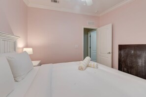 A bedroom with a bed, a nightstand, a lamp, and a door.