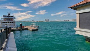 A waterfront dock with a boat named 'NUSSE' and a building with a tiled roof.