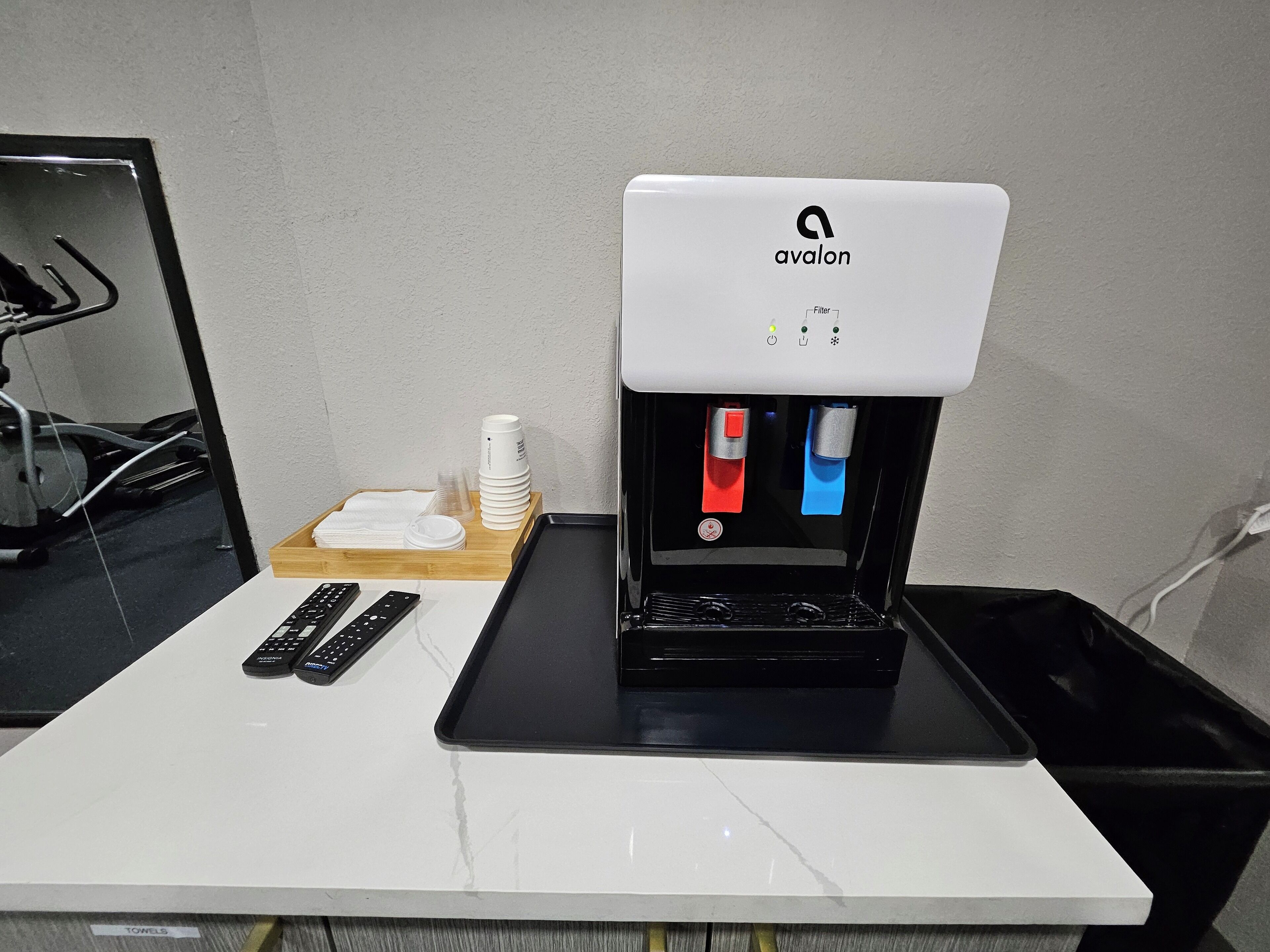 A coffee machine with a control panel and a tray table.