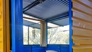 A room with two beds, a window, and a view of trees. - Room in Cabin - Rafting Hut by The River (San Agustin Lanquin)