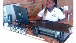 Un mostrador de recepción con una computadora y un cartel que dice "RECEPTION".