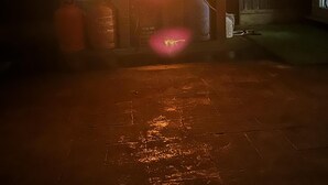 A brick fireplace with a visible fire, surrounded by a wooden fence and a metal gate. - 3 bed House in Blackpool With Cinema & hot tub (Blackpool)