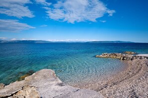A coastal landscape with clear blue sea, rocky shoreline, and distant mountains. - Apartment ANETTE with sea view, Groundfloor, 300m from the the beach (Ravni)