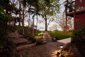 A paved pathway leading to a building with a view of the sea. - Orquidea 1Bdr apartment with Pool & Garden view (Playa Tamarindo)